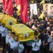 عناصر من كشافة «المهدي» يحملون نعوش قياديّ بـ«حزب الله» وعائلته خلال تشييعهم بالضاحية الجنوبية لبيروت (أ.ب)