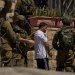 عناصر من القوات الإسرائيلية تعتقل فلسطينياً في أحد شوارع بلدة عناتا بالضفة الغربية المحتلة الثلاثاء (أ.ب)