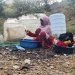 يمنية في تعز تغسل الملابس في مخيم مؤقت للنازحين جراء التصعيد الحوثي (رويترز)