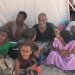 يمني مع أطفاله بمخيم للنزوح بعد مقتل زوجته في هجوم حوثي بطائرة مسيرة (رويترز)