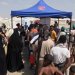 يمنيون فارون من القتال يقفون في طابور للحصول على قسائم غذائية قرب عدن أمس (رويترز)