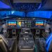 صورة توضح البنية الهندسية لقمرات القيادة الحديثة (Glass Cockpits) حيث تنتشر الشاشات الرقمية المتقدمة، وتظهر لوحة التحكم المركزية (Center Pedestal) الواقعة بين مقعدي القبطان والمساعد. في هذه المنطقة تحديداً، يتواجد جهاز الإرسال والاستقبال (Transponder) الذي يستخدمه الطيارون لطباعة رموز الطوارئ الثلاثية (7700، 7600، 7500) لتظهر فوراً على رادارات المراقبين الأرضيين (ويكيبيديا)